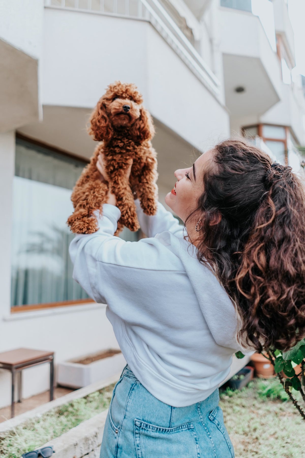 Mujer sosteniendo a su perro en brazos — MIWLAB®